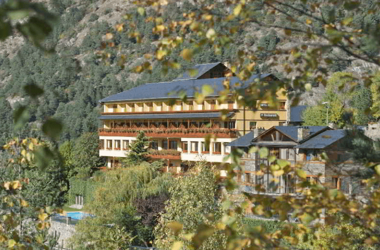 Hotel Abba Ordino Babot entre vegetació a la muntanya.