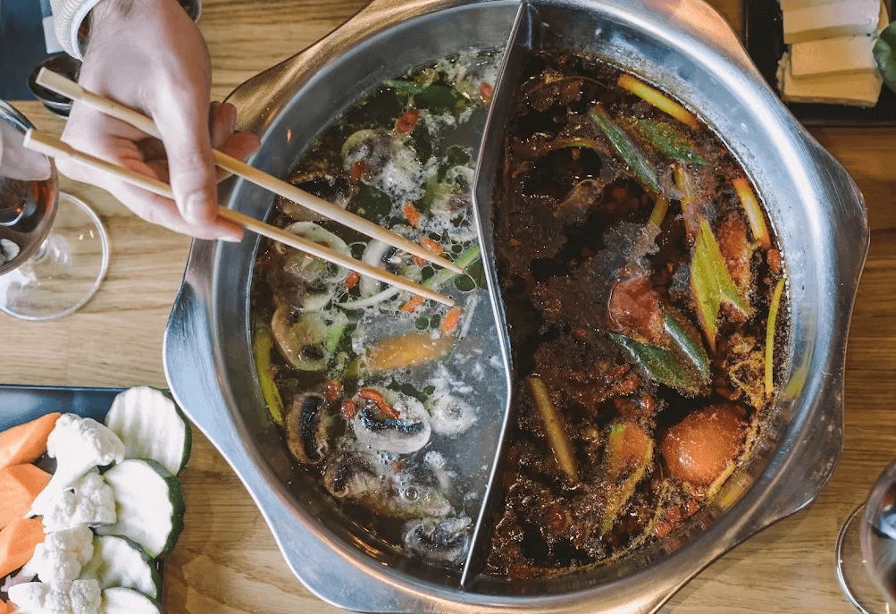 Hot pot de Sichuan con unos palillos.