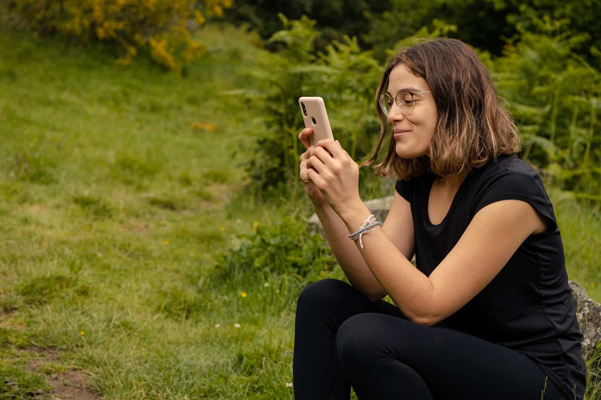 chica usando su móvil con conexión a internet en la naturaleza