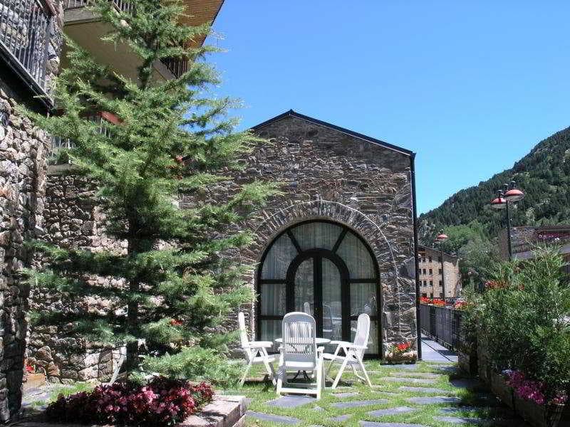 Fachada del Hotel Bonavida de Andorra en un dia soleado. Parte exterior del jardín.
