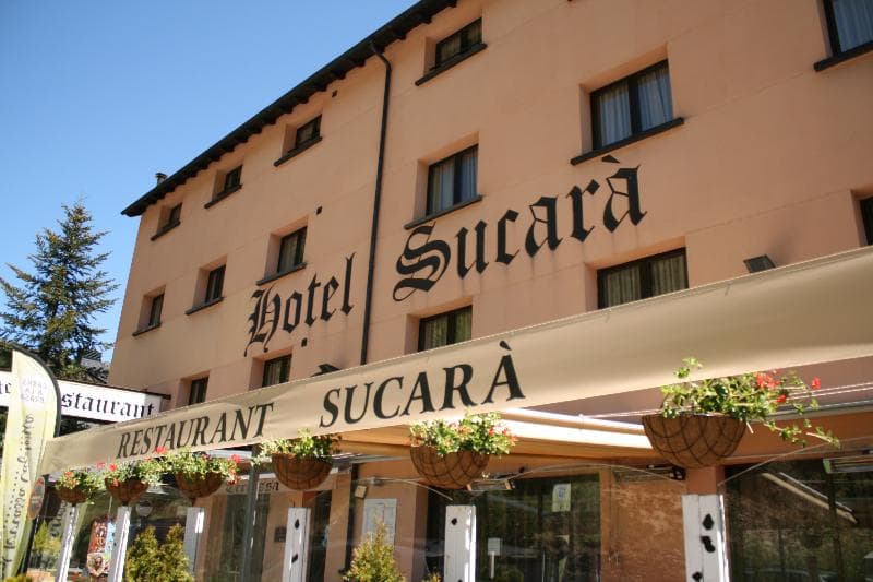 Fachada del hotel sucarà de Andorra en un dia soleado con el restaurante del hotel en la parte baja