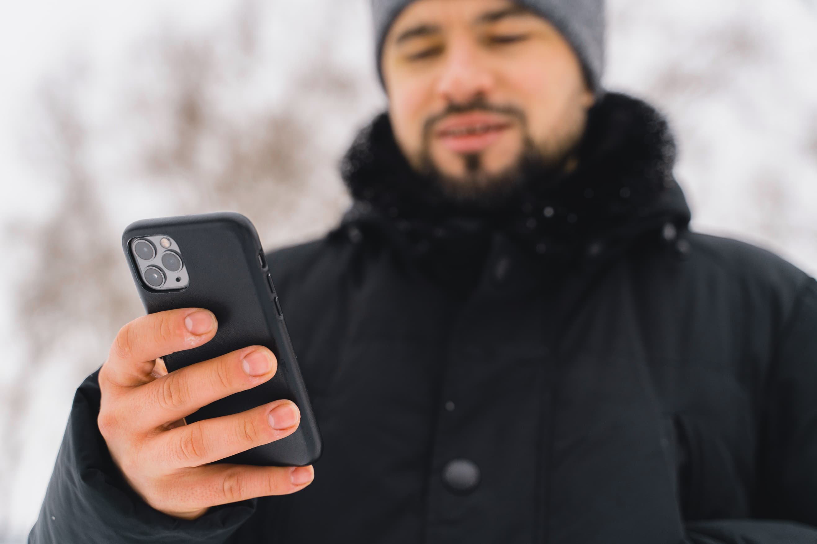 Hombre mirando el teléfono en la nieve Andorra